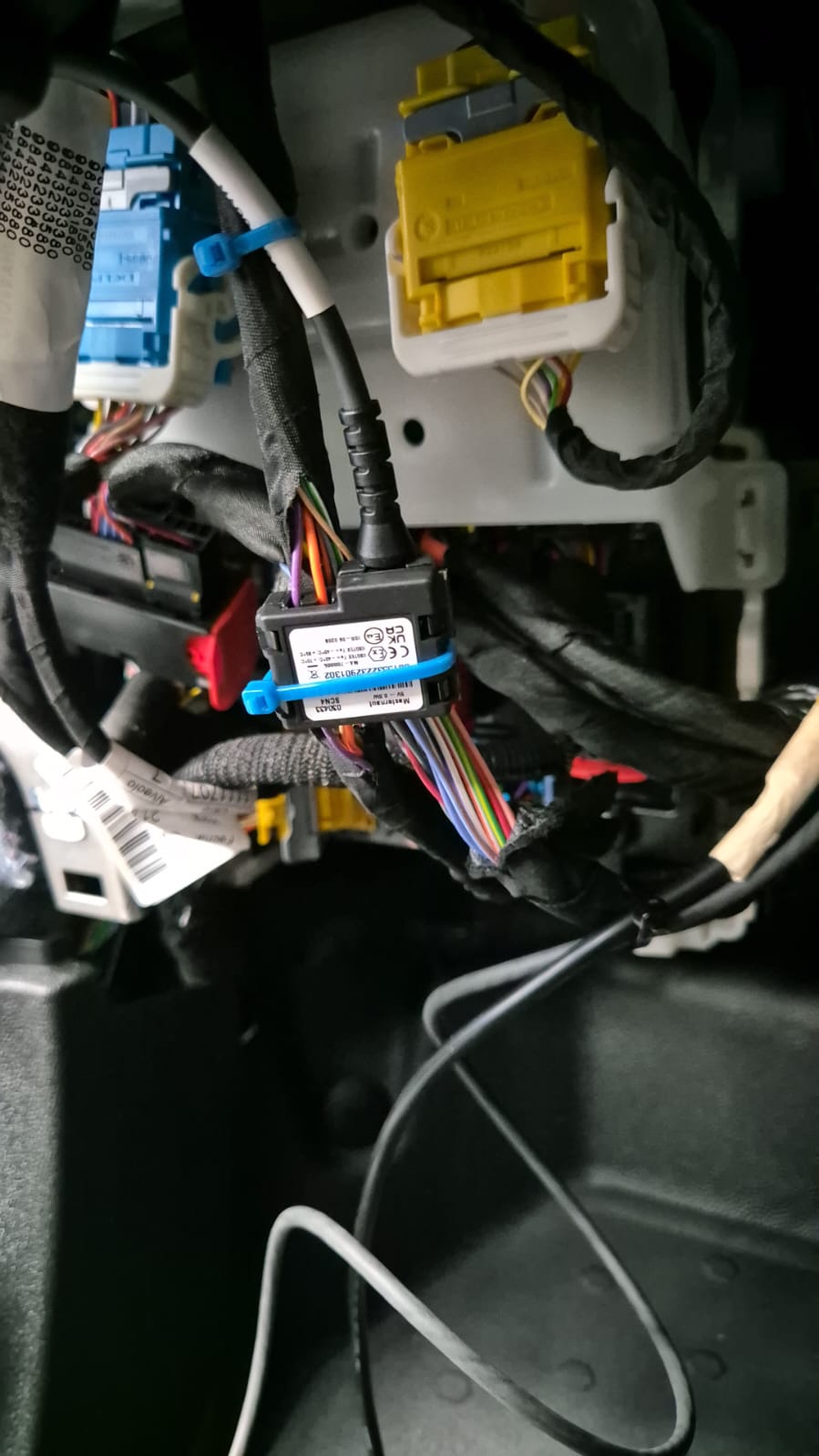 Technician mounting a GPS tracking module under a dashboard